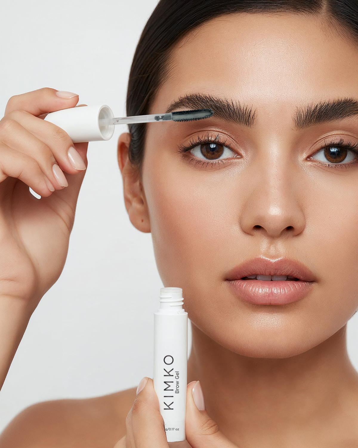 Woman sculpting her eyebrows with KIMKO Brow Gel.